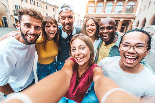 Multicultural friends taking selfie picture with smart mobile phone outdoors - Happy young people having fun hanging on city street - Life style concept with guys and girls laughing at camera