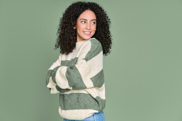 Young happy latin woman looking aside at copy space isolated on green background. Smiling female...