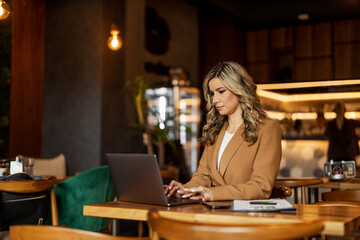 Businesswoman at cafe using laptop