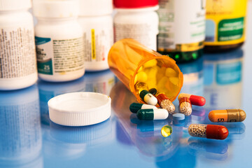 Mix of pills capsules supplements and Pharmacogenomics on blue medical table.