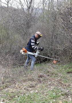 persona desbrozando un terreno