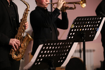 Band of brass instruments saxophone and trumpet playing on stage concert
