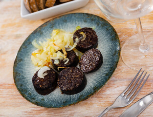 Delicious fried morcilla (blood sausage with rice) and grilled onion served on plate. Spanish dish