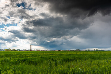 Wieża wiertnicza na tle wiosenej łąki / Drilling rig against the background of a spring meadow