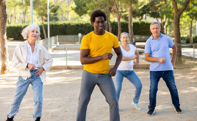 Happy multiracial adult people with different ages having fun doing aerobics outdoor