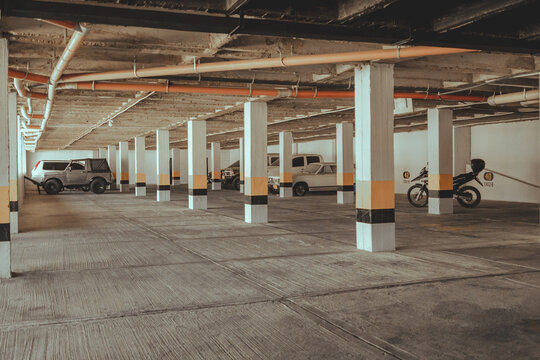 Parking of a building with cars and motorcycles