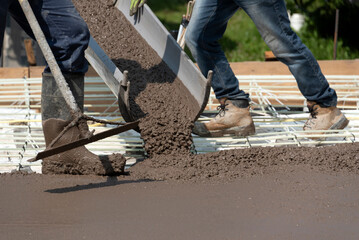 Workers pouring concrete for a stamped floor