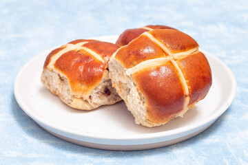 Freshly baked hot cross buns on white plate. Traditional easter food, horizontal