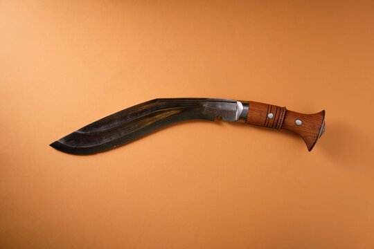 An ancient kukri knife on an orange background