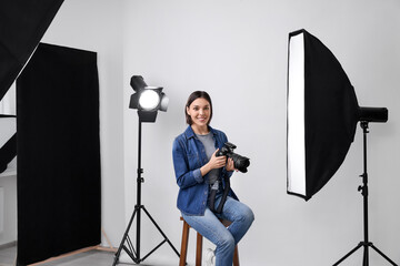 Professional photographer with camera in modern photo studio