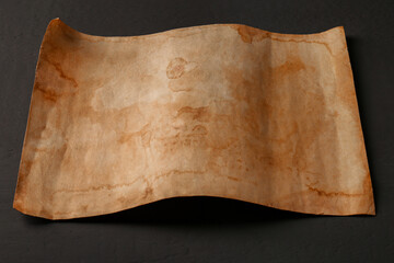 Sheet of old parchment paper on grey wooden table
