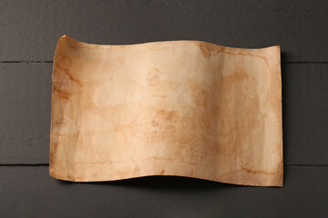 Sheet of old parchment paper on grey wooden table, above view