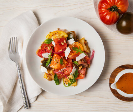 Gourmet heirloom tomato salad with herbs, cheese and pine nuts