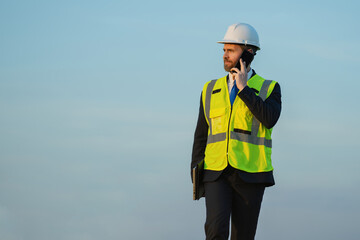 construction business owner in helmet talk on phone about building, copy space