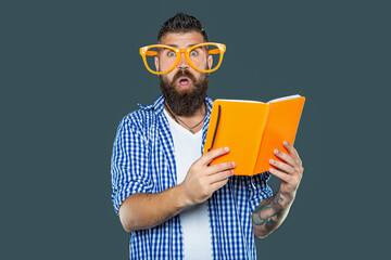 surprised funny bearded man in party glasses reading book