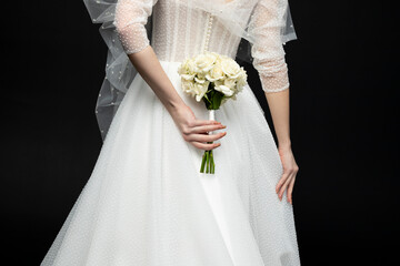 A beautiful charming girl, the bride in a luxurious and elegant white wedding dress, holding a...