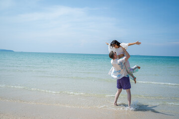 Fototapeta na wymiar Happy young beautiful couple man and woman on the beach,Fun,Holiday.
