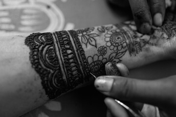 Applying Beautiful henna art on hands. Bridal design. Wedding Mehendi.