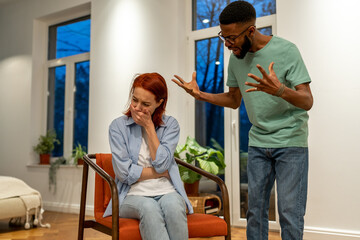Conflict of multiethnic couple African American man and caucasian woman. Angry guy shouts at girl...