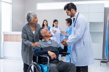 Mature doctor walking through the hallway to visit patient in hospital. 