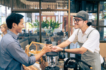 Fototapeta na wymiar Asian attractive men receive hot coffee from waiter in coffee house. 