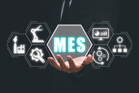 MES - Manufacturing Execution System concept, Businessman hand holding Manufacturing Execution System icon on virtual screen.
