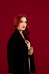 Naklejka premium Elegant woman looking at the camera while posing against a colored background.