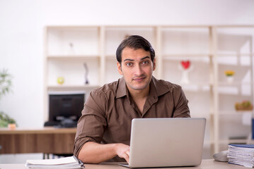 Young attractive employee sitting in the office