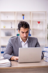 Fototapeta premium Young male employee and too much work in the office