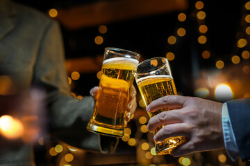 food and drink male friends are happy drinking beer and clinking glasses at a bar or pub.