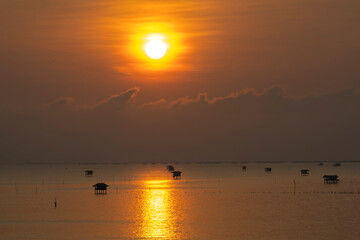 Beautiful Landscape view of  morning sun over the fishing village by the sea  in Thailand