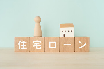 住宅ローンと書かれたブロックと人形と家