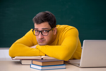 Young male student sitting in the classroom