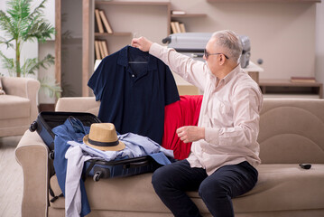 Old man preparing for trip at home