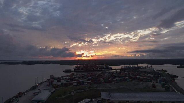 aerial view of stunning hues of a sunset in the middle of clouds over Buenaventura port, Colombia, captured in a breathtaking aerial view.