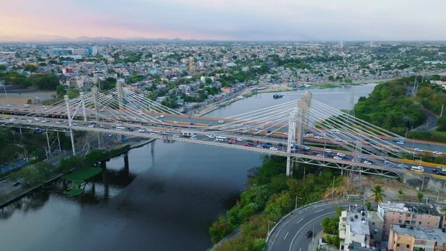 Car traffic on Juan Bosch and Juan Pablo Duarte bridges at sunset, Santo Domingo in Dominican Republic. Aerial drone panoramic view