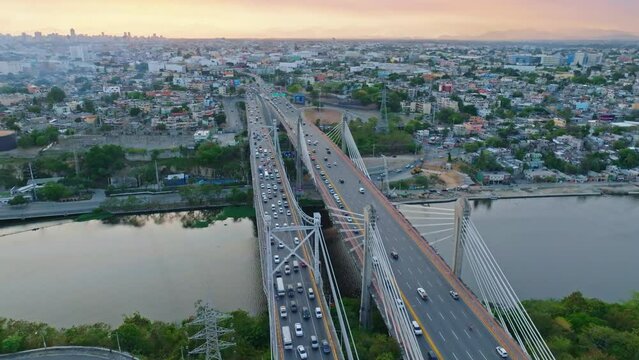Car traffic on Juan Bosch and Juan Pablo Duarte bridges at dusk, Santo Domingo in Dominican Republic. Aerial orbiting