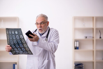 Old male doctor radiologist working in the clinic