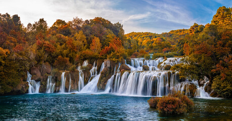 Krka, Croatia - Panoramic view of the famous Krka Waterfalls in Krka National Park on a bright autumn morning with amazing colorful autumn foliage and blue sky