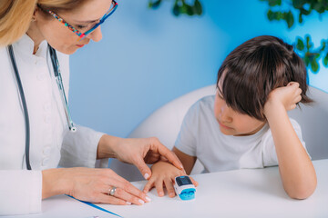 Pulmonology pediatrician measuring blood oxygen levels with pulse oximeter