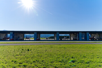 Fototapeta premium Red and white Northrop F-5E Tiger II fighters of Patrouille Suisse at hangar at Swiss Air Force airbase Emmen, Canton Lucerne, on a sunny spring day. Photo taken March 22nd, 2023, Emmen, Switzerland.