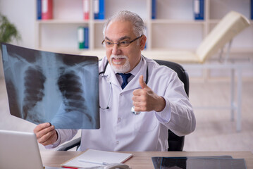 Old male doctor radiologist working in the clinic