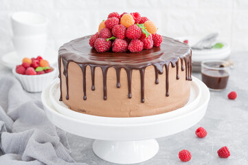 Layered honey chocolate cake with glaze and fresh raspberries on top. Delicious chocolate cake.