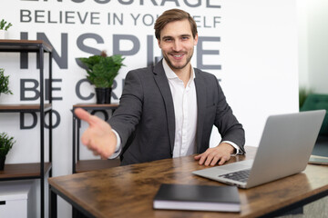 Naklejka premium office worker stretches out his hand while sitting in the office at the workplace