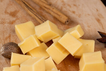Yellow hard cheese sliced on a board