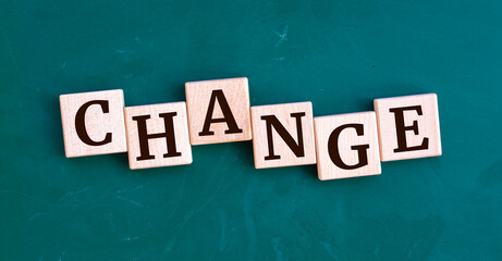 CHANGE message sign on a wooden cubes on chalkboard background.