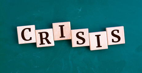 Crisis message sign on a wooden cubes on chalkboard background.