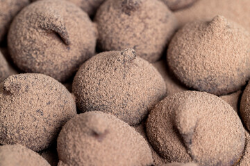 a large number of sweet candies in chocolate powder
