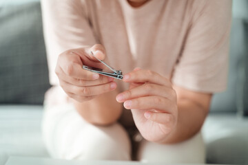 Woman cutting fingernails using nail clipper, Healthcare, Beauty Concept.