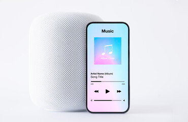 Sample music player app on mobile phone in front of wireless speaker on white background
